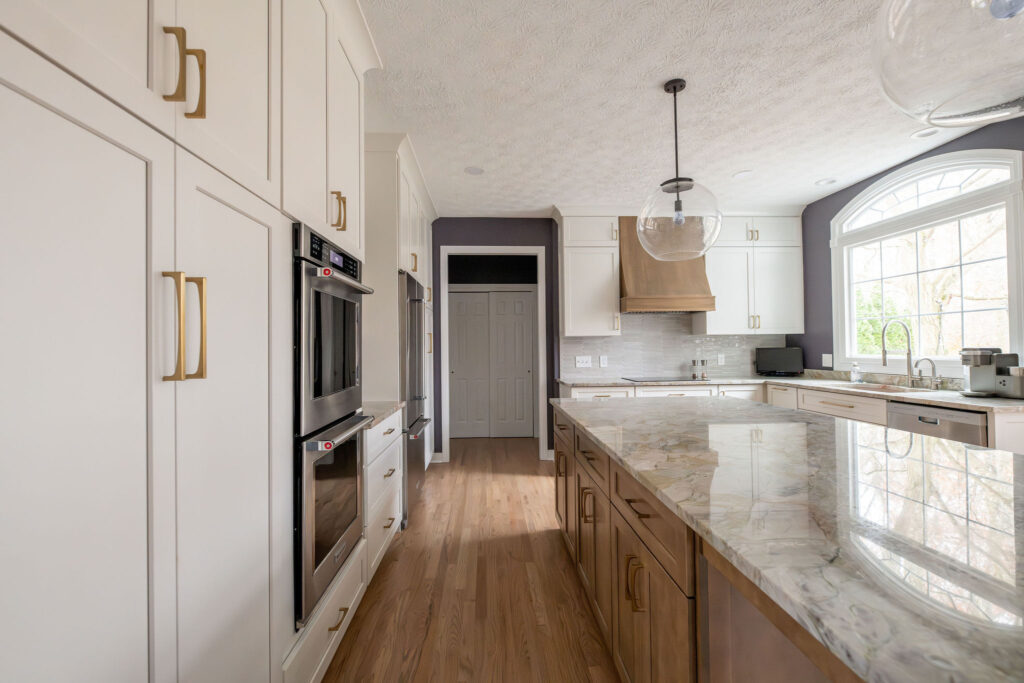 Kitchen remodel in Aurora Ohio with light cabinets, hardwood floors and accents of purple. Lindsey Putzier interior design 