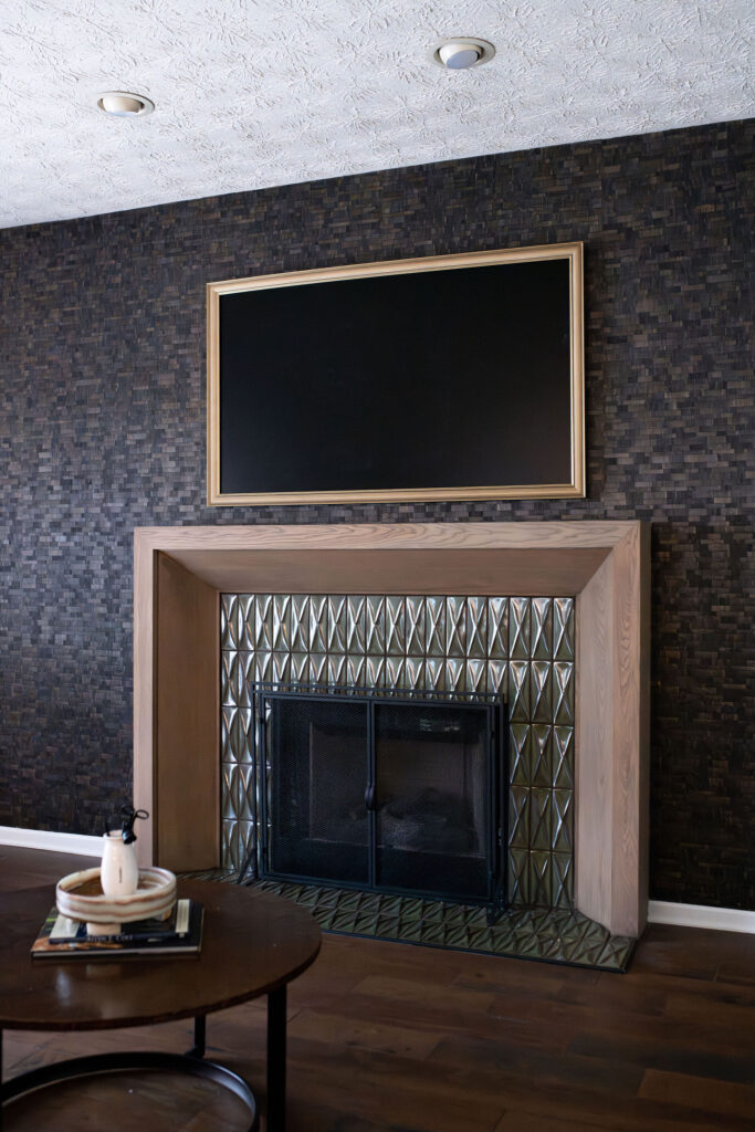 Updated mantle in the living room with dark hardwood flooring, and tiled accent wall. Lindsey Putzier interior design