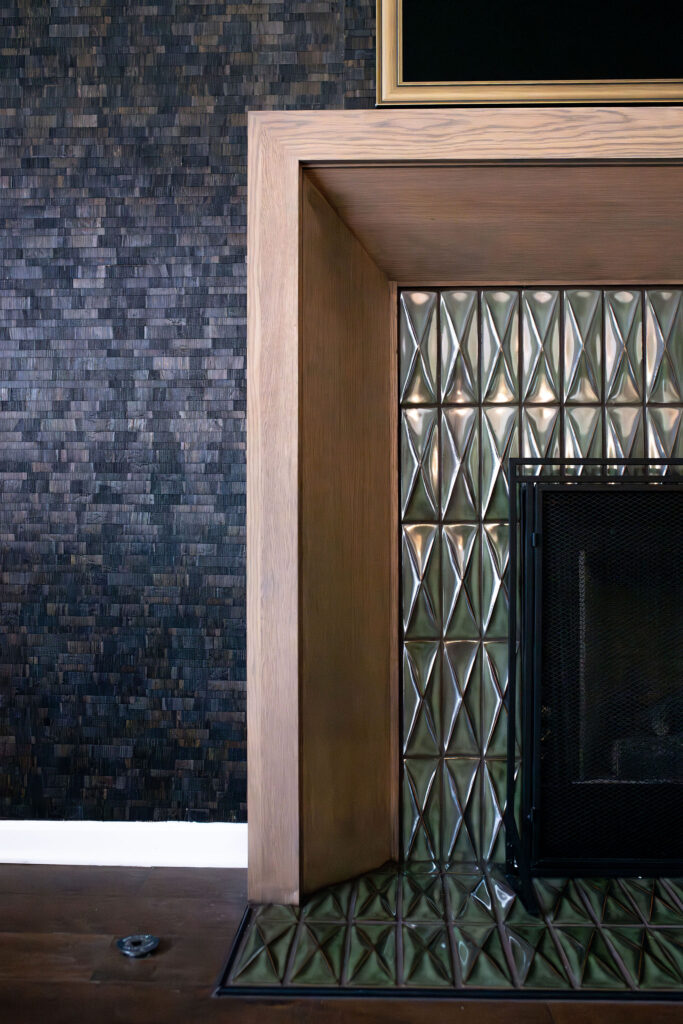 Redesigned mantle in the living roo with medium wood, green accent tiles, and accent wall behind. Copley Ohio Lindsey Putzier interior design 
