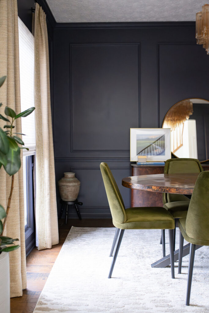 Dining room in Copley Ohio with deep wooden table, dark green upholstered chairs, and cream custom window treatments. Lindsey Putzier interior design 