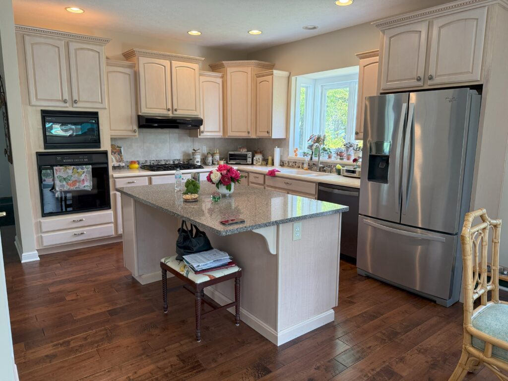Before of the kitchen with dates beige cabinetry, dated stone countertops, and black appliances. Aurora Ohio, interior design Lindsey Putzier