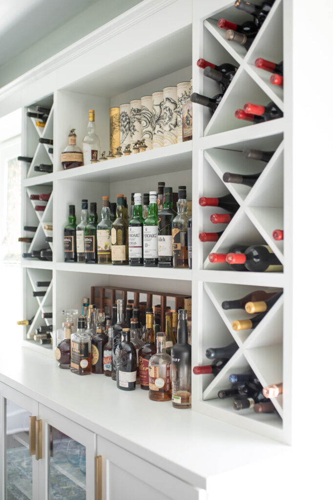 In home bar with custom buily in shelving to hold bottle and display alcohol. Lindsey Putzier interior design 