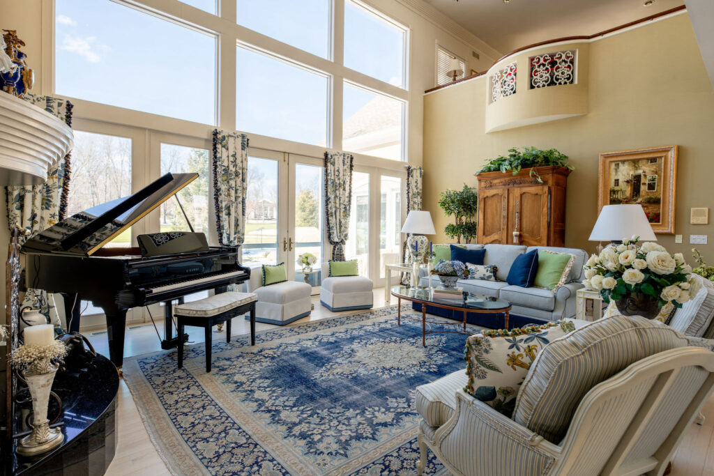 After of the redesigned living room with a cool tones blue color palette, french inspiration, and updated furniture. Aurora Ohio interior design Lindsey Putzier 