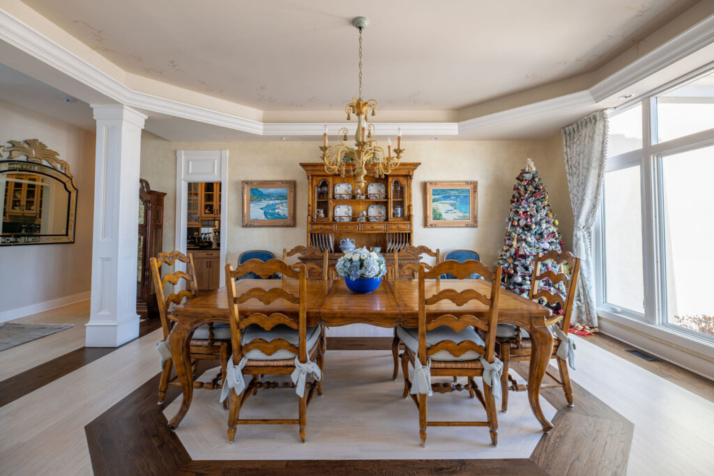 After of the dining room with light blue chair cushions, new blue upholstered chairs and updated window treatments. Lindsey Putzier interior design Aurora Ohio 