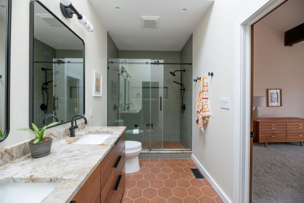 After of master bathroom with updated glass shower, tiled floors, marble countertops and updated fixtures. Akron Ohio interior design Lindsey Putzier 