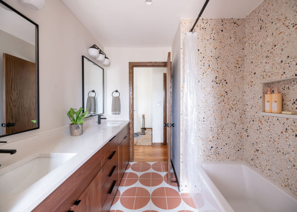 After of the secondary bathroom with patterned tile flooring, wooden vanity, stone shower and countertops, and updated fixtures. Akron Ohio Lindsey Putzier Interior Design 