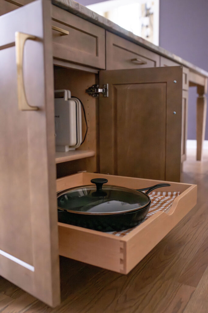 Pullout cabinets that allow easy access to pans and skillets in the kitchen. Lindsey Putzier interior design