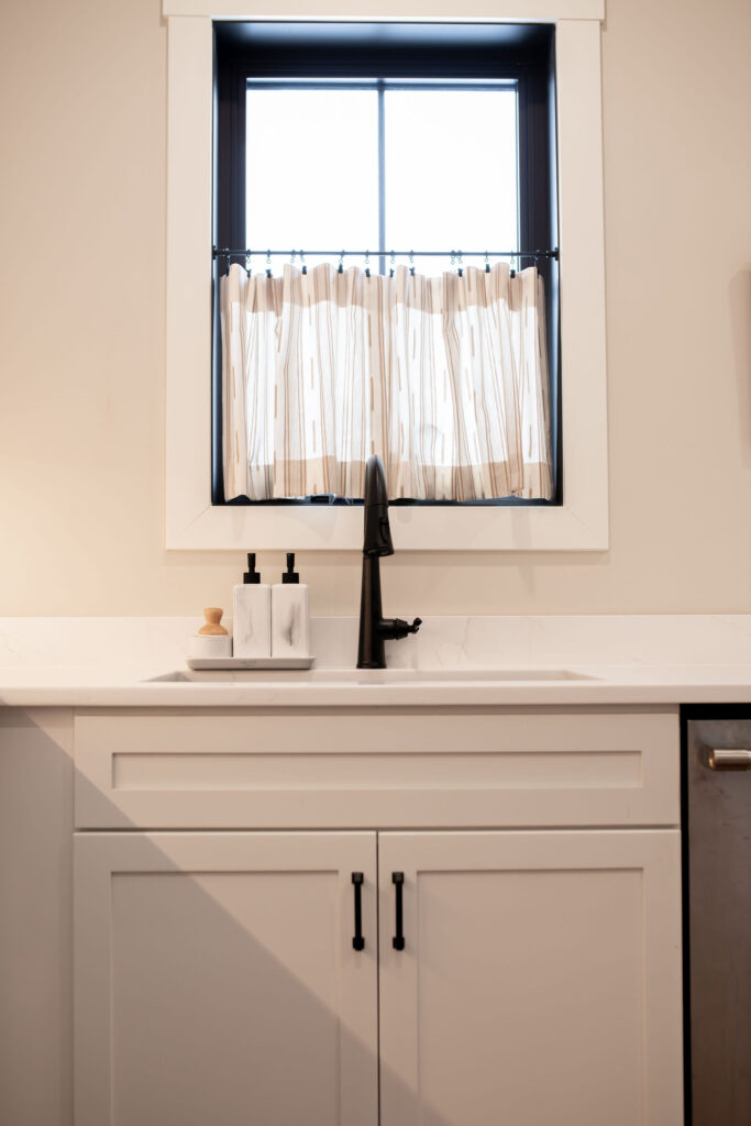 Mudroom with white cabinets and white countertops. Lindsey Putzier interior design