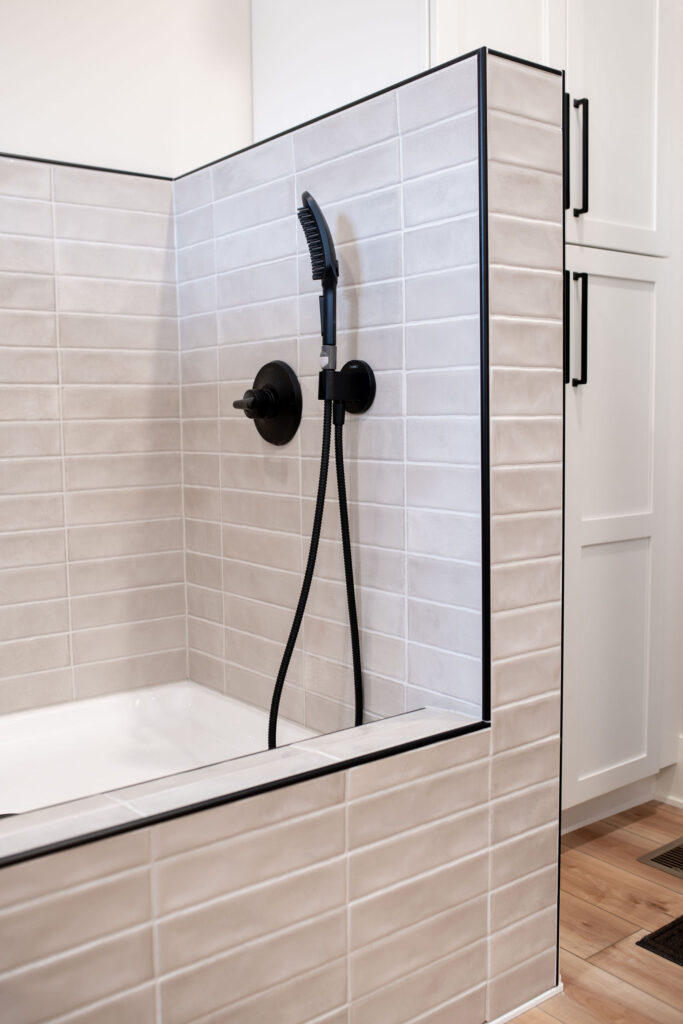 Custom built dog washing station in the mudroom with durable light tiles, and adjustable nossel. Lindsey Putzier Interior Design