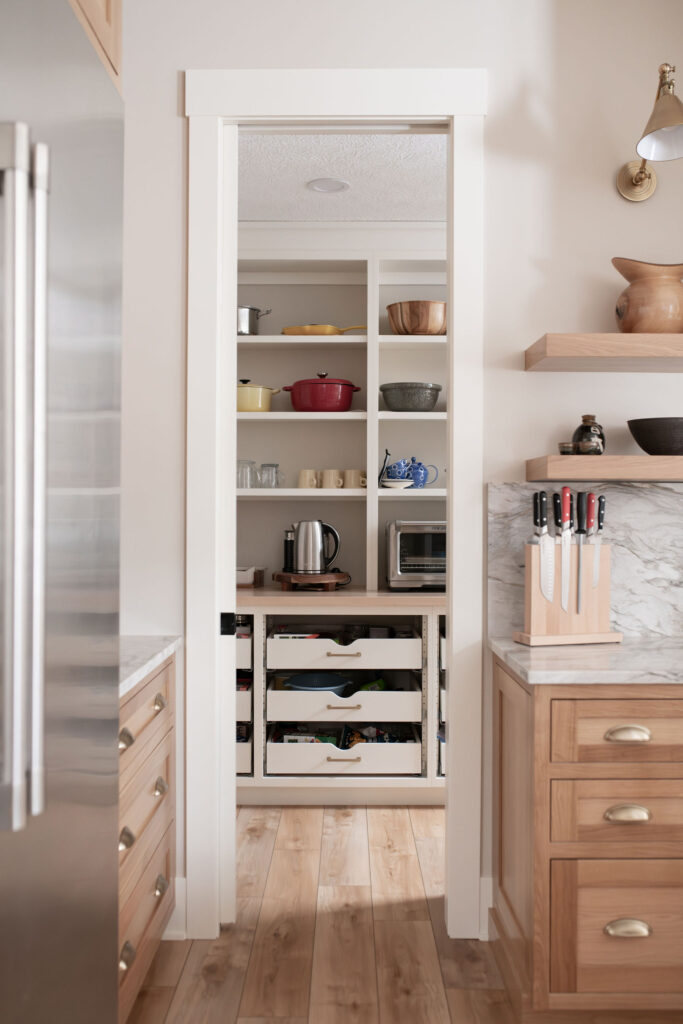 Butlers pantry with open access to the kitchen, pull out drawers for storage, and extra small appliances. Lindsey Putzier interior design 
