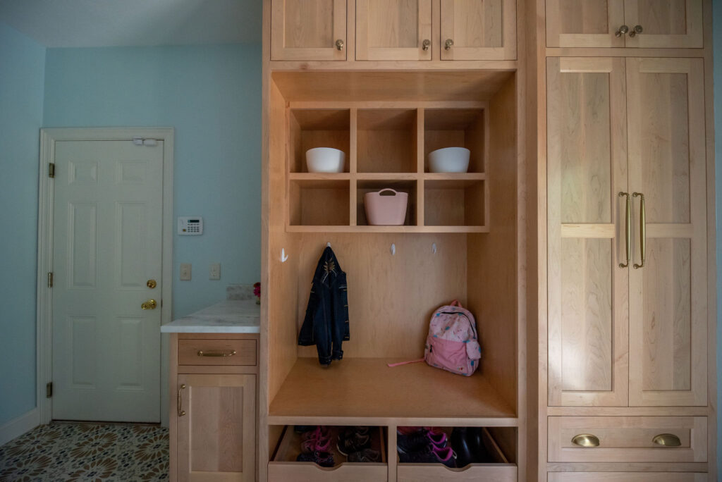 Built in storage in the mudroom with hooks for jackets, bins for shoes and cubbies for items. Lindsey Putzier interior design