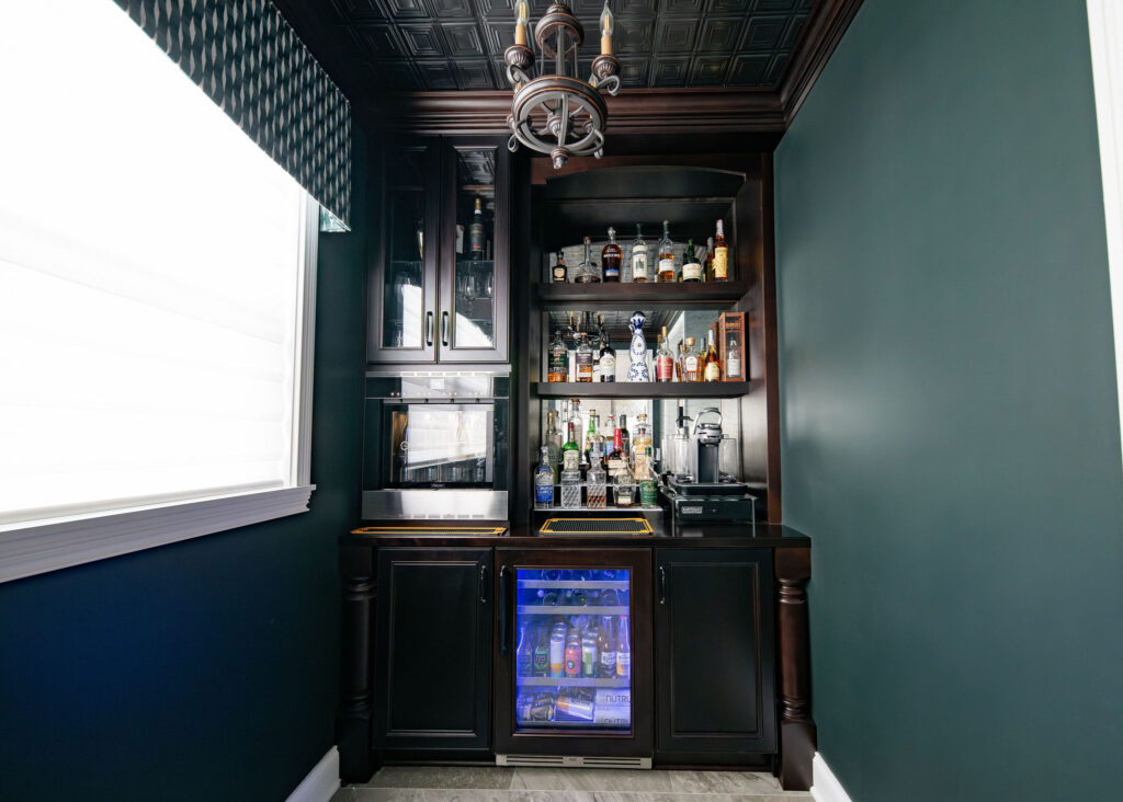 In office bar and beverage station with wine dispenser, wine fridge, and liquor display. Lindsey Putzier interior design 