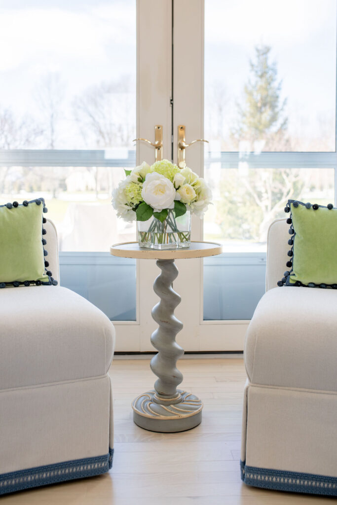 Chairs in the living room with blue trim on the base and a small twisty table. Lindsey Putzier interior design Aurora Ohio 