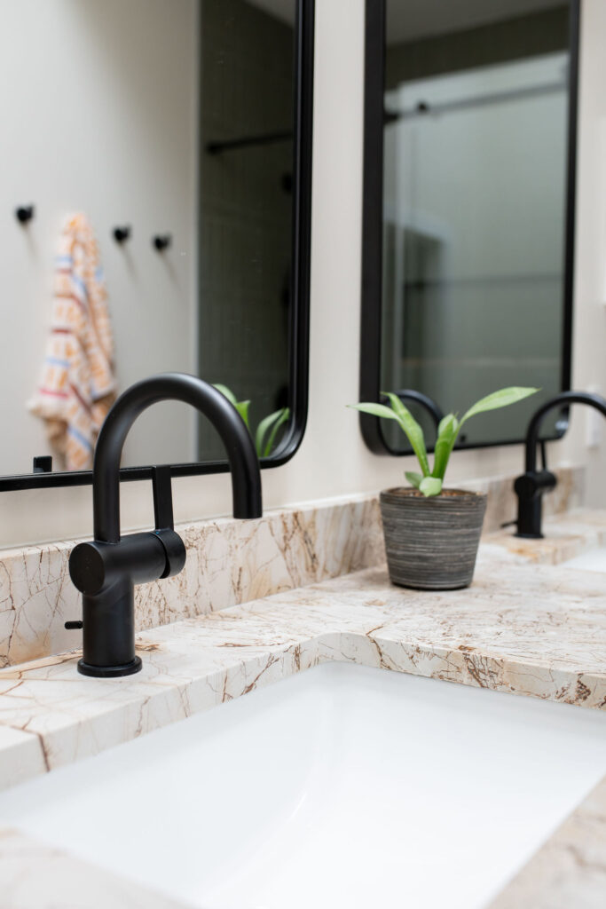 Master bathroom with sleek black metal light fixtures and faucets. Lindsey Putzier interior design Akron Ohio 