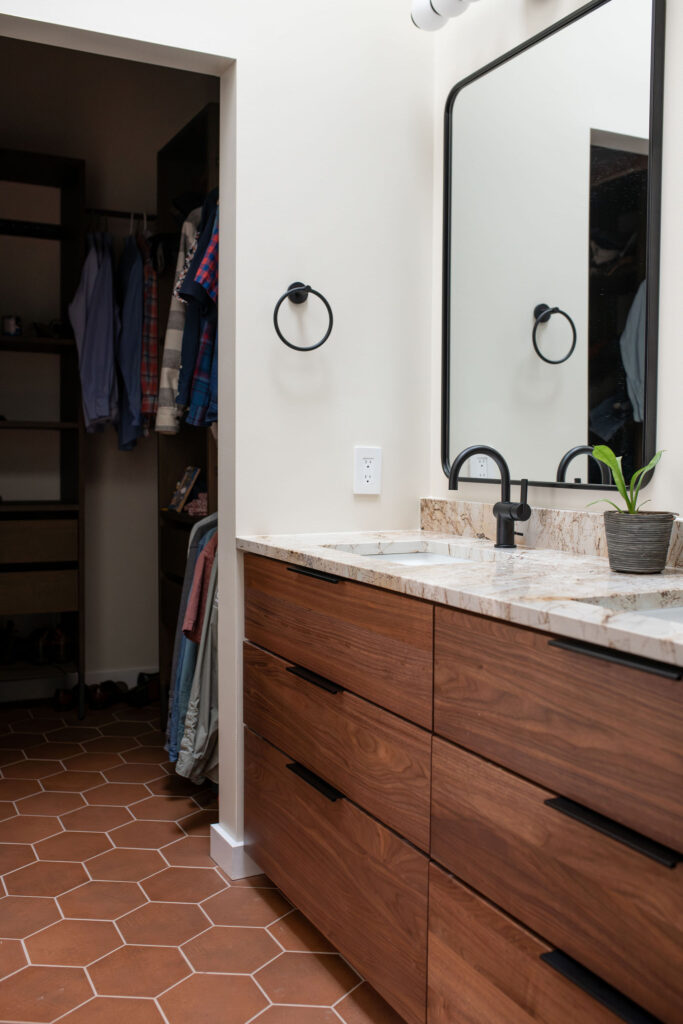 Master bathroom with updated earthy tile flooring, warm cabinetry, and marble countertops. Lindsey Putzier interior design Akron Ohio 