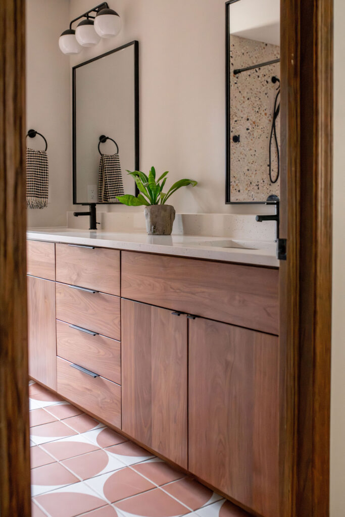 Secondary bathroom with earthy wooden finishings, black sleek fixtures, and patterend tile flooring. Lindsey Putzier interior design Akron Ohio. 