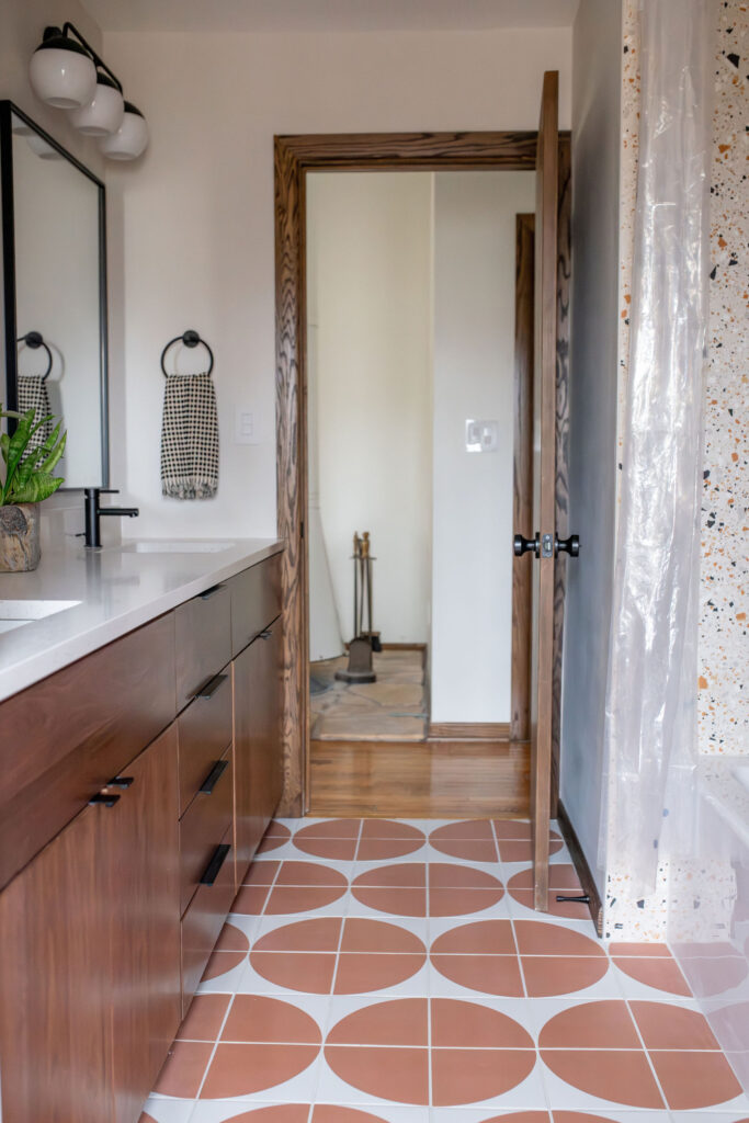 After of the secondary bathroom with patterned tile flooring, wooden vanity, stone shower and countertops, and updated fixtures. Akron Ohio Lindsey Putzier Interior Design 