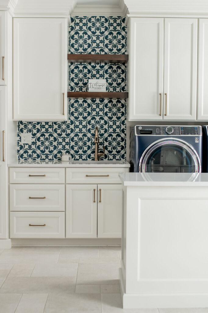 Mudroom integrated with the laundry room, patterned backsplash and light tile flooring. Lindsey Putzier interior design