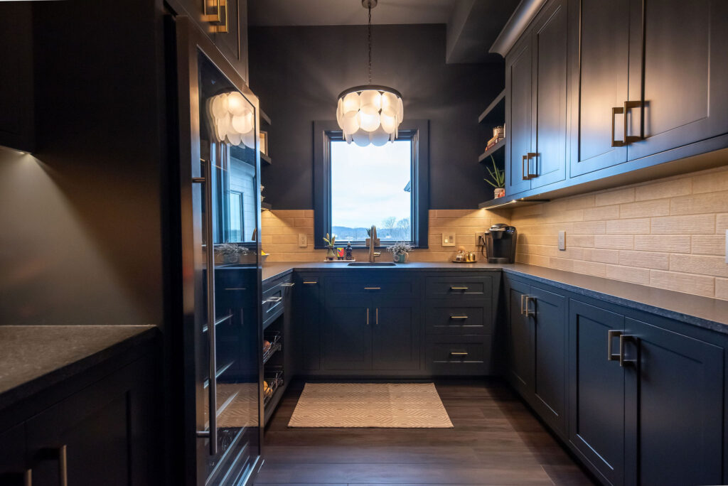 Butlers pantry with more dramatic features, dark cabinets, recess lighting, and dark countertops. Lindsey Putzier interior design 