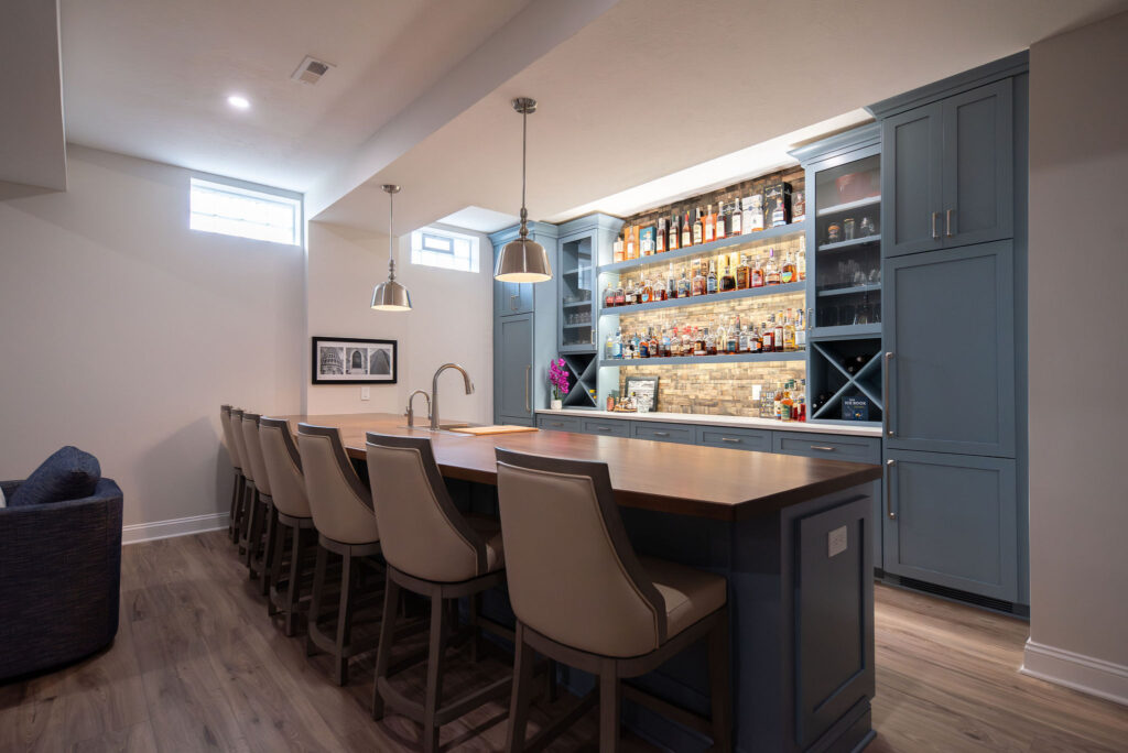 In home bar with with stool seating, large built in cabinets, and liquor storage. Lindsey Putzier interior design 
