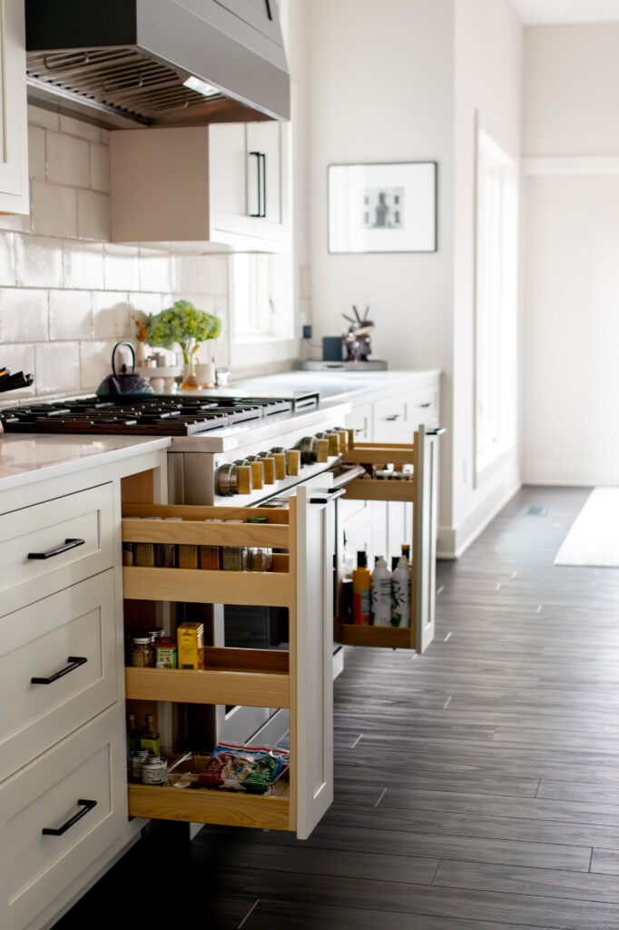 Custom pullout cabinets with storage for spices, oils, and utensils. Lindsey Putzier interior design