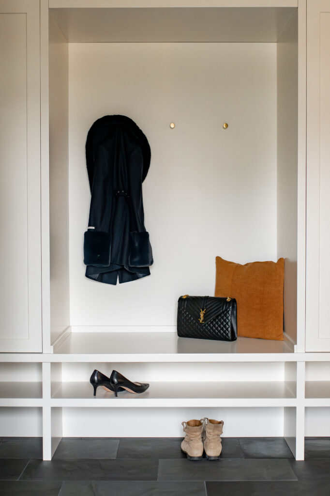 Custom built in storage with shoe space, hooks and open shelving. Lindsey Putzier interior design