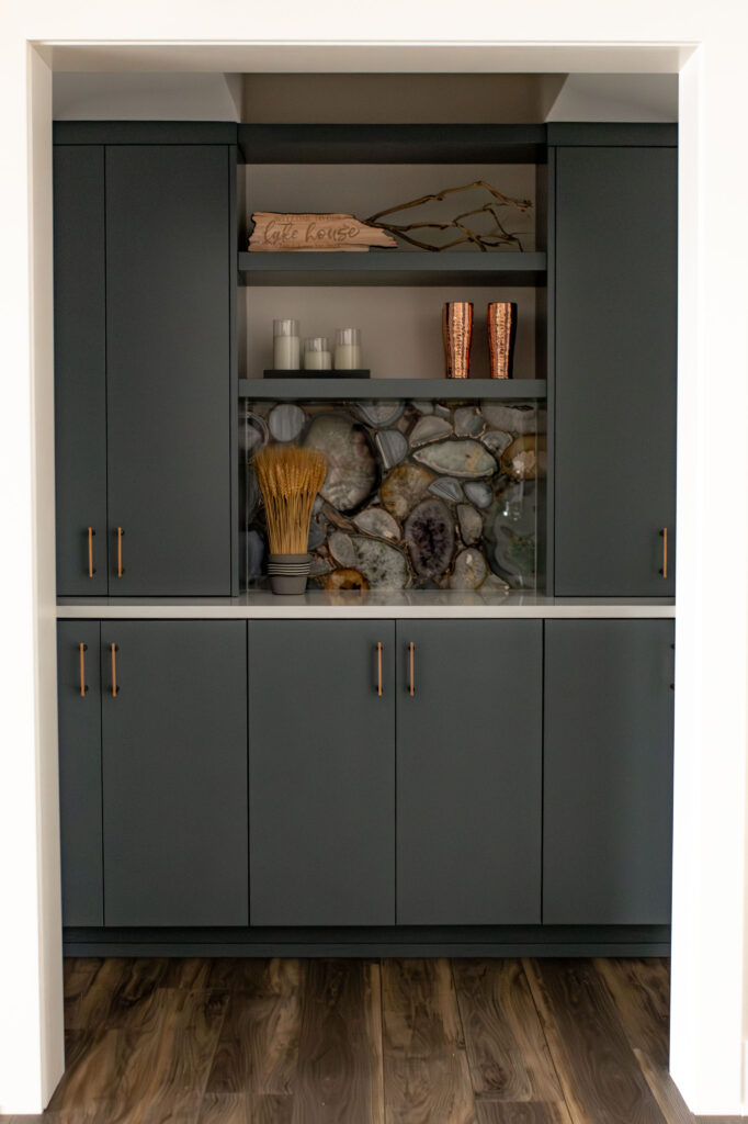 In home bar with grey cabinetry, stone backsplash, open shelving and golden accents. Lindsey Putzier interior design 