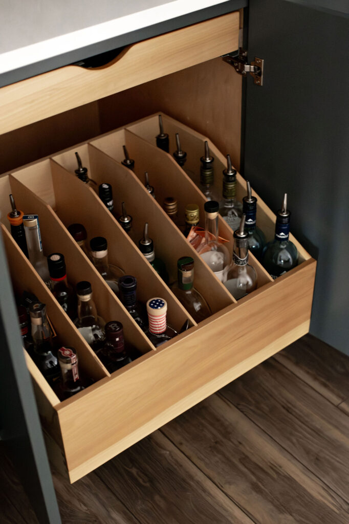 Pull out bottle storage in kitchen with bar. Lindsey Putzier interior design 