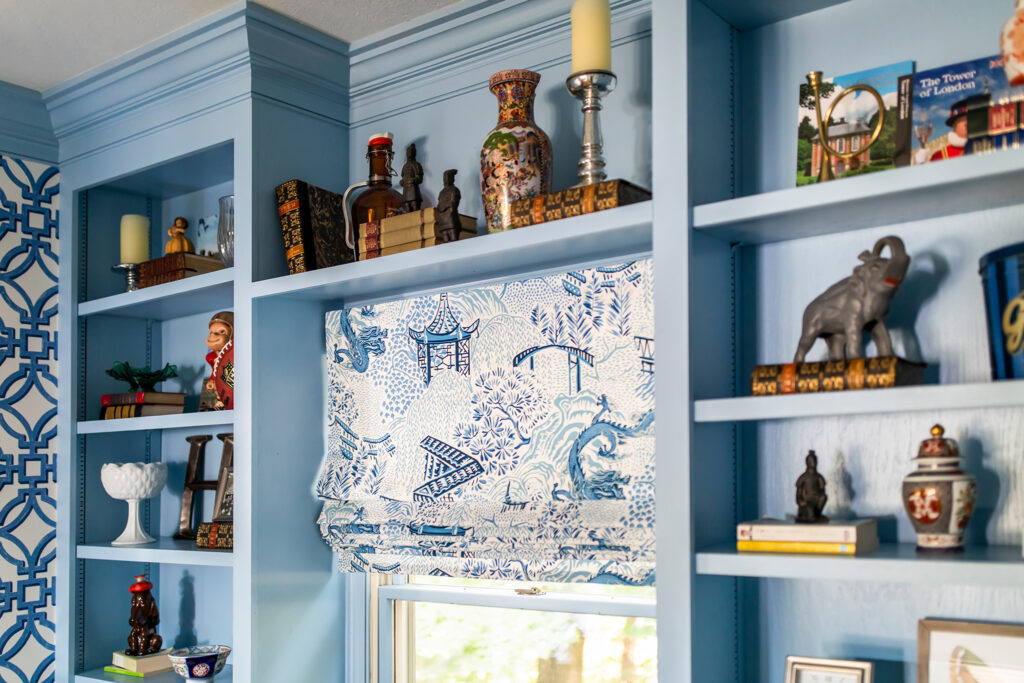 Oriental window treatment in the home office with shelf of styling pieces. Lindsey Putzier interior design Hudson Ohio