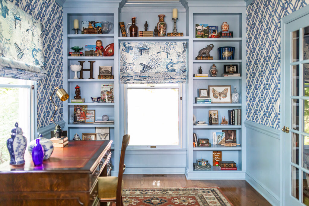 Home office with built in bookshelves full of trinkets and design styling pieces. Lindsey Putzier interior design Hudson Ohio 