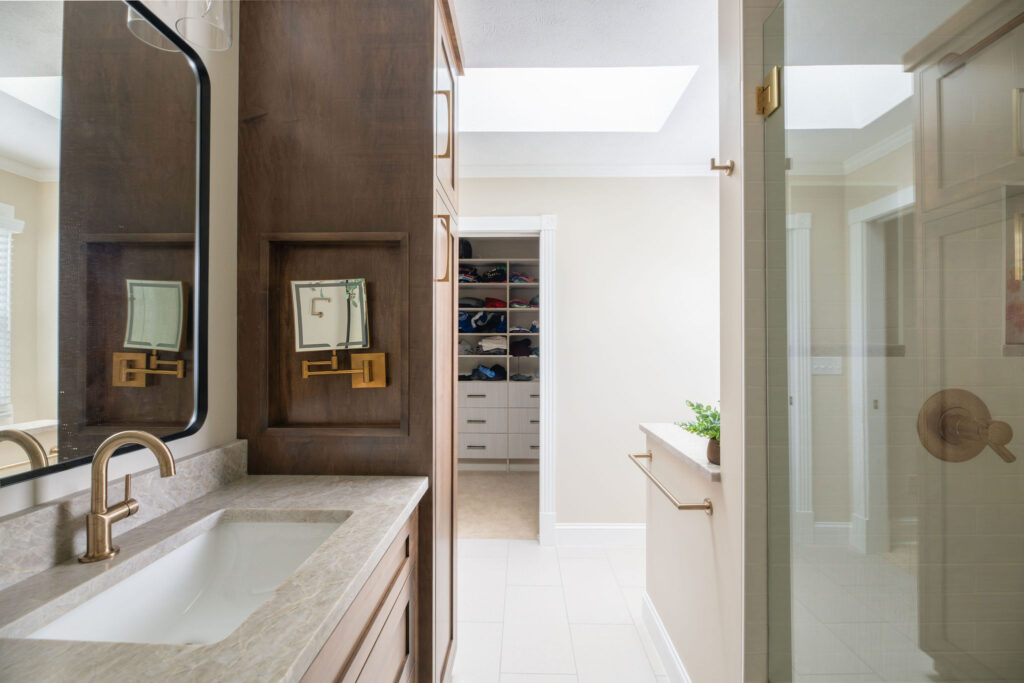 After of the master bathroom with updates layout, neutral colors, and golden finishes. Lindsey Putzier interior design Hudson Ohio 