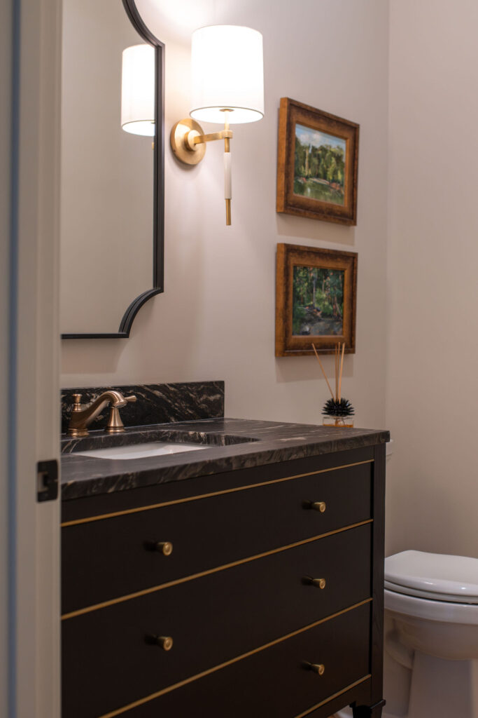 Dark black vanity in the powder room with golden faucet and accents. Lindsey Putzier interior design Hudson Ohio 
