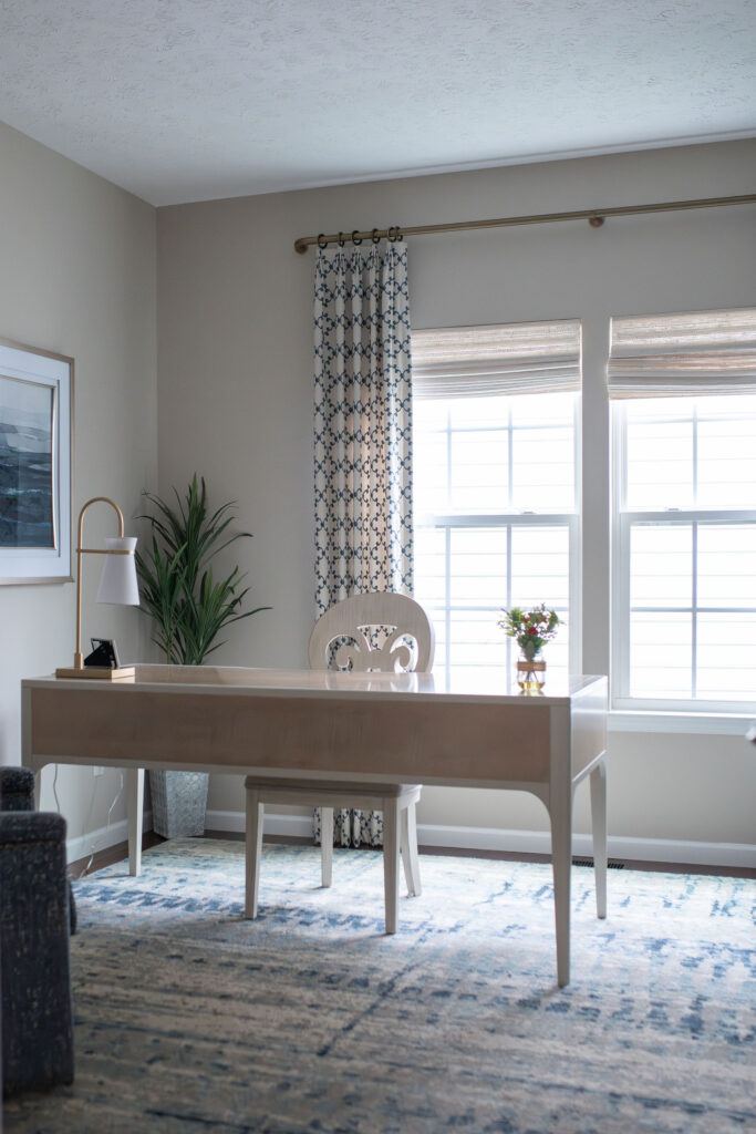 Home office with patterned window treatments, gold accents, and wooden and white desk. Lindsey Putzier interior design Hudson Ohio 