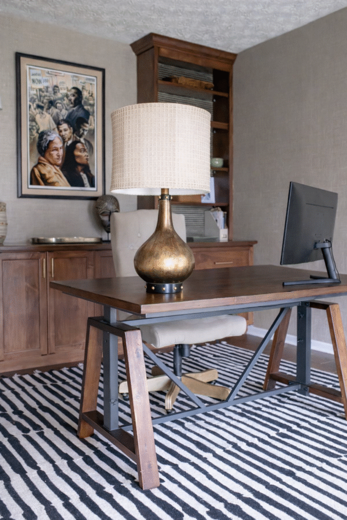 Home office with wooden desk, golden accent lamp, and striped rug. Lindsey Putzier interior design Hudson Ohio 