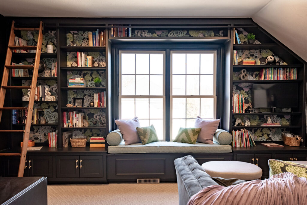 Large wall of custom shelving, wallpaper backed, and built in ladder. Lindsey Putzier interior design Hudson Ohio 