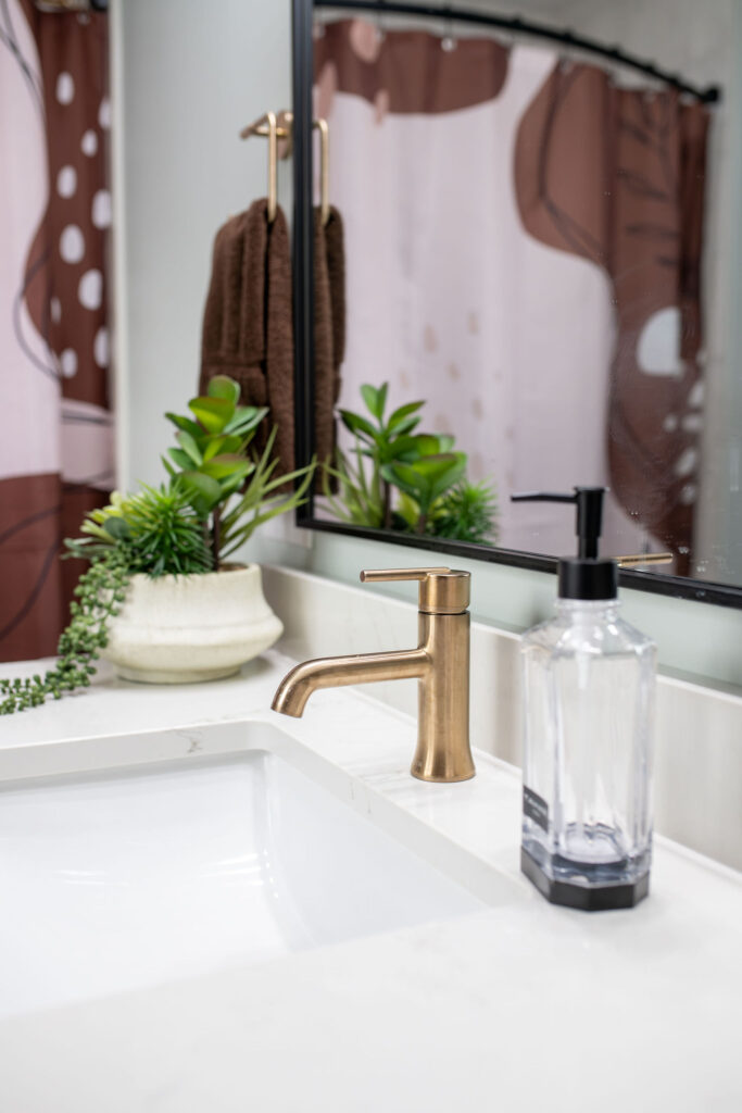 Kids bathroom with golden faucet and stone countertops. Lindsey Putzier interior design Hudson Ohio 