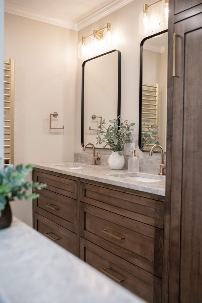 After of the master bathroom with more neutral walls, lighter wooden vanity, stone countertops, and updated modern finishes. Lindsey Putzier interior design 