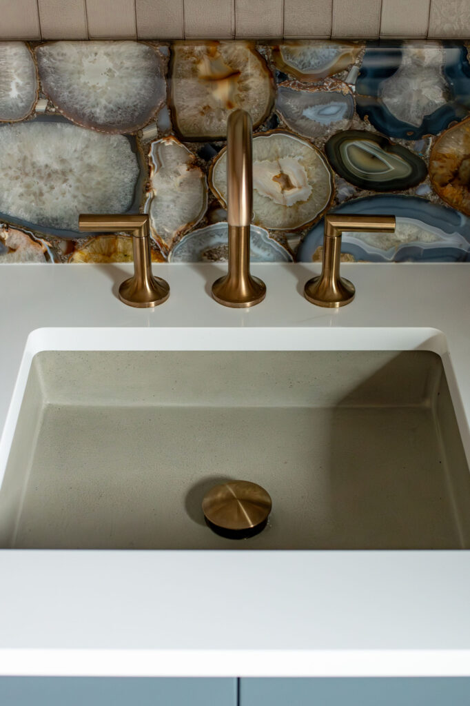Golden faucet in the powder room with white countertops. Lindsey Putzier interior design Hudson Ohio 