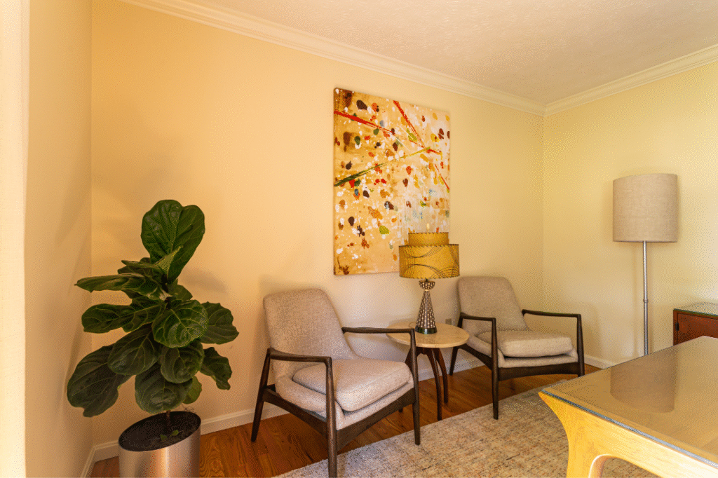 Home office with painting on the wall, sitting chairs, and an accent lamp. Lindsey Putzier interior design Hudson Ohio 