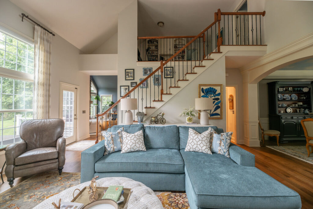After of living room with blue sofa, new ottoman and lighter finishes. Lindsey Putzier Interior Design Aurora Ohio 