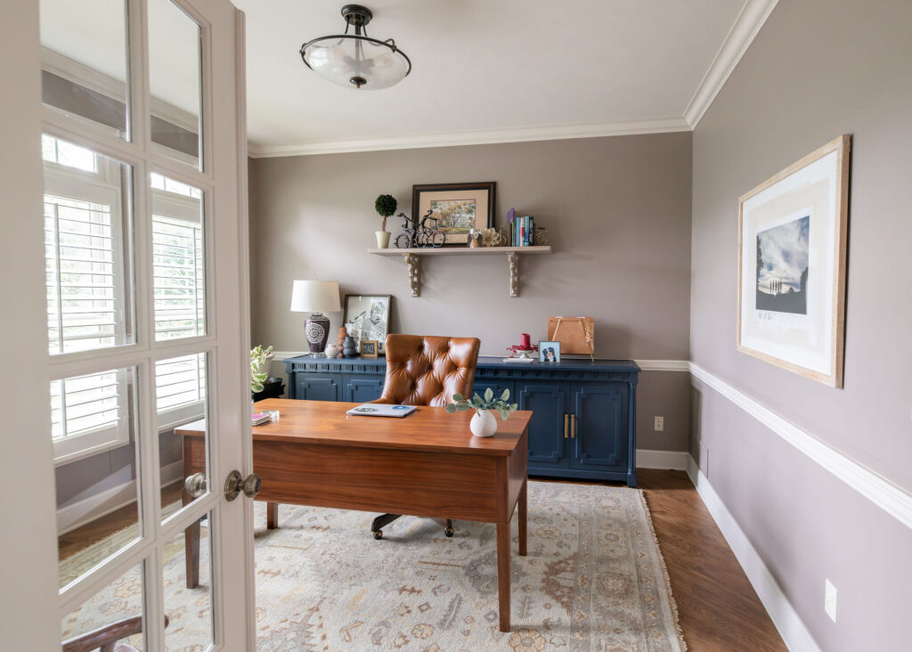 After of the office with hardwood floors and a rug, blue sideboard, and lighter wall color. Lindsey Putzier Interior Design Aurora Ohio   