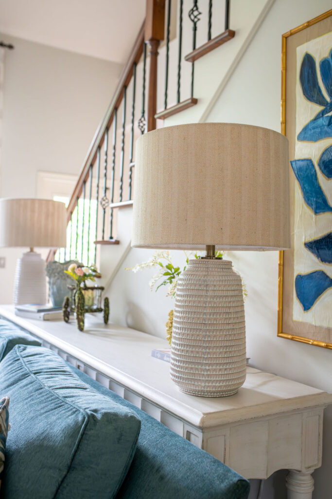 White sideboard behind the couch with two lamps and design accents. Lindsey Putzier Interior Design Aurora Ohio  