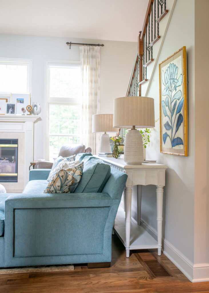 Blue sofa in the living room with sunken detail, and white sideboard with two lamps.  Lindsey Putzier Interior Design Aurora Ohio  
