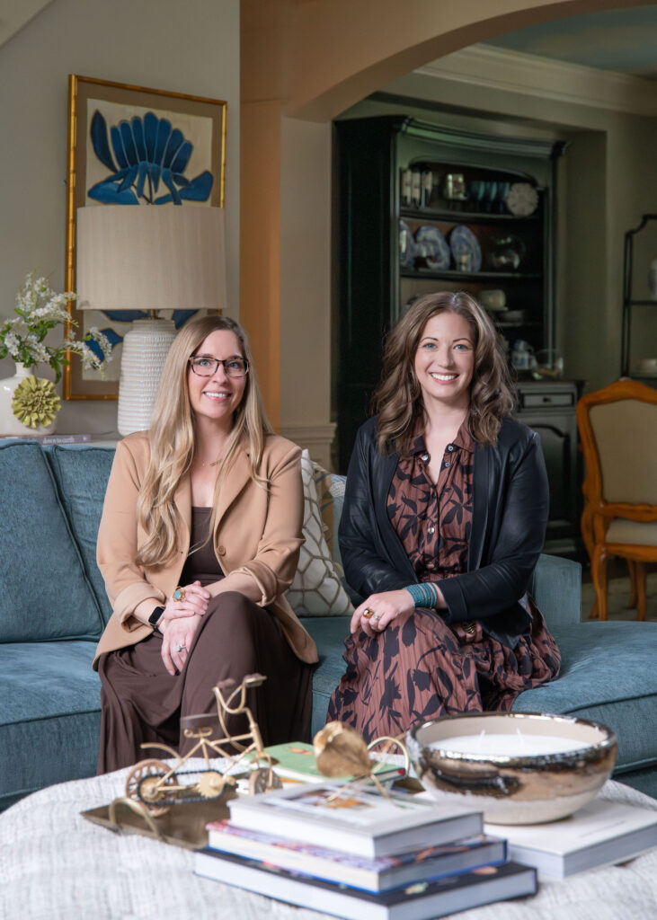 Lindsey Putzier, founder and principal designer, and Julianna Watts, senior designer, sitting in the living room of Aurora Ohio Home. Interior design