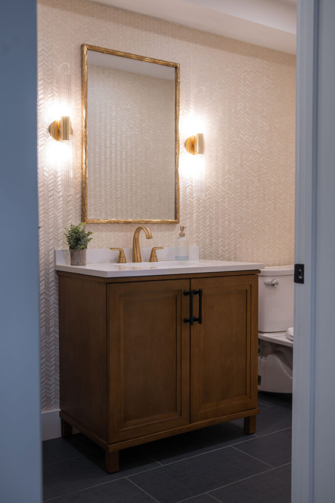 After of the updated bathroom with textured wallpaper, updated vanity and gold fixtures. Cuyahoga Falls Ohio. Lindsey Putzier interior design