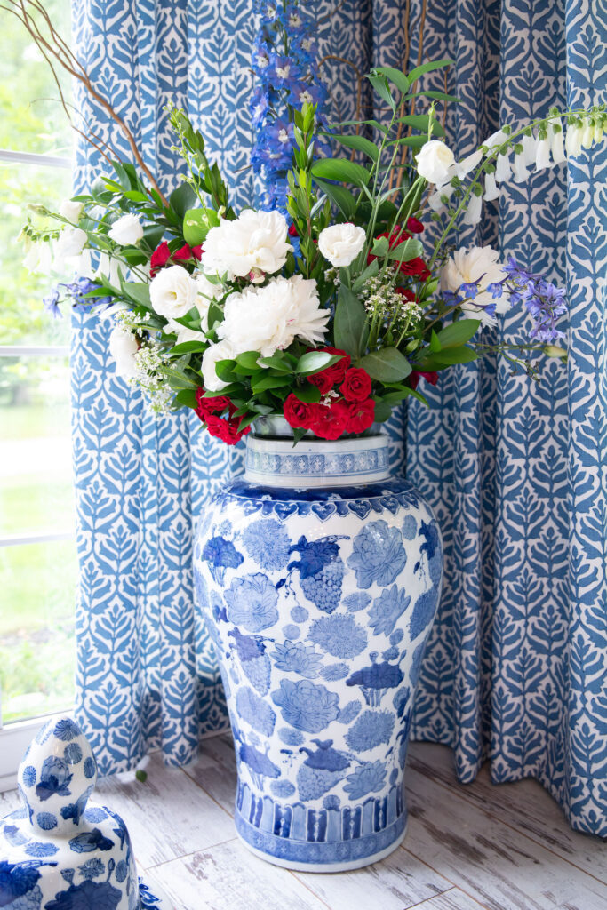 Flower arrangement in glass vase with red, white, and green florals. Hudson Home and Garden Show 2026, interior design, Lindsey Putzier