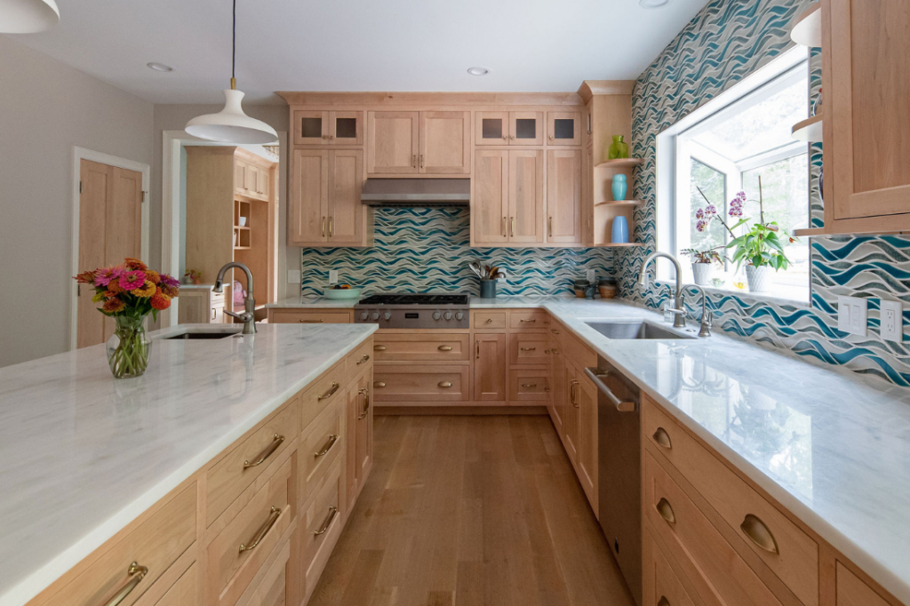 Kitchen with blue and green backsplash tiles in a wave pattern and warm wooden cabinets. Lindsey Putzier Design Studio Hudson Ohio