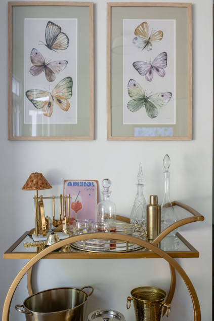 bar cart with golden fixtures and butterfly artwork. Lindsey Putzier interior design Hudson Ohio