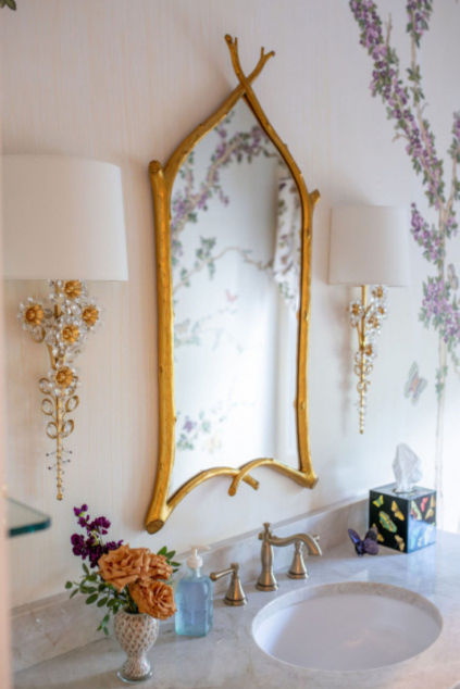 Powder room with golden mirror ad golden floral inspired sconces. Lindsey Putzier interior design Hudson Ohio
