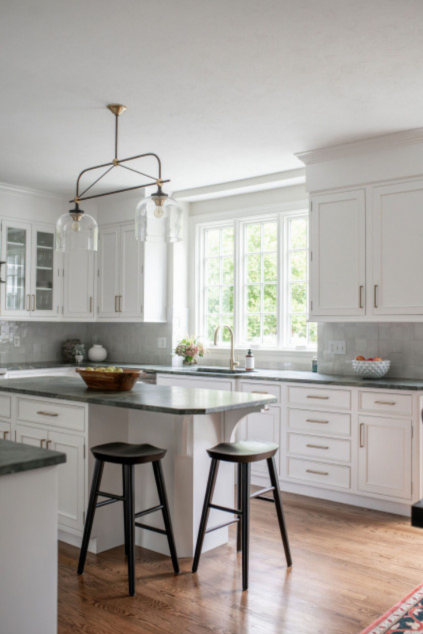 Kitchen with breakfast bar, white cabinetry, and warm wood floors. Lindsey Putzier interior design Hudson Ohio 